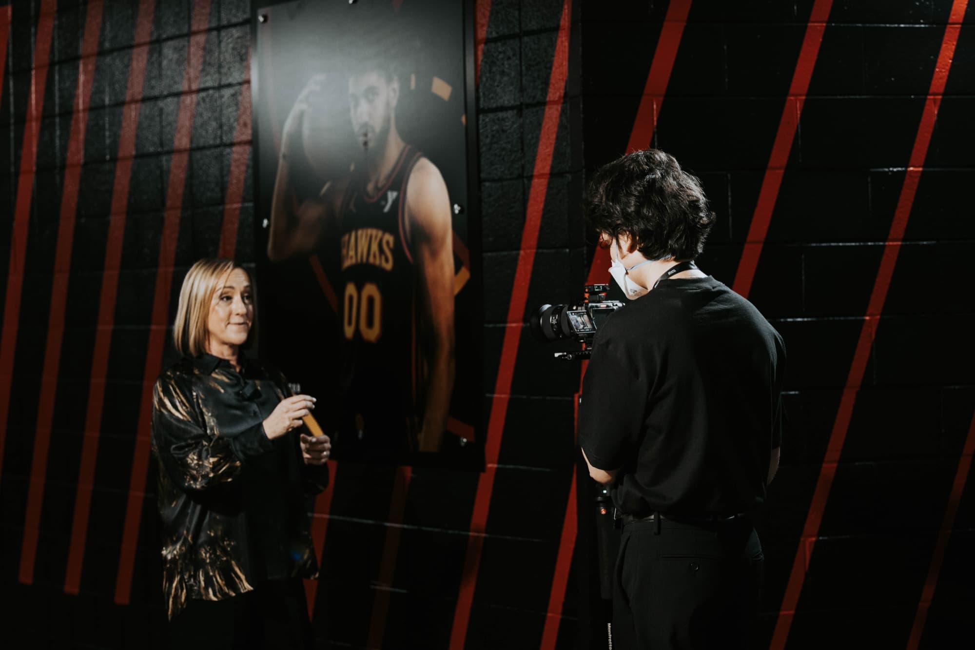 A Griffith Media operator filming a keynote speaker backstage on a Sony cinema camera