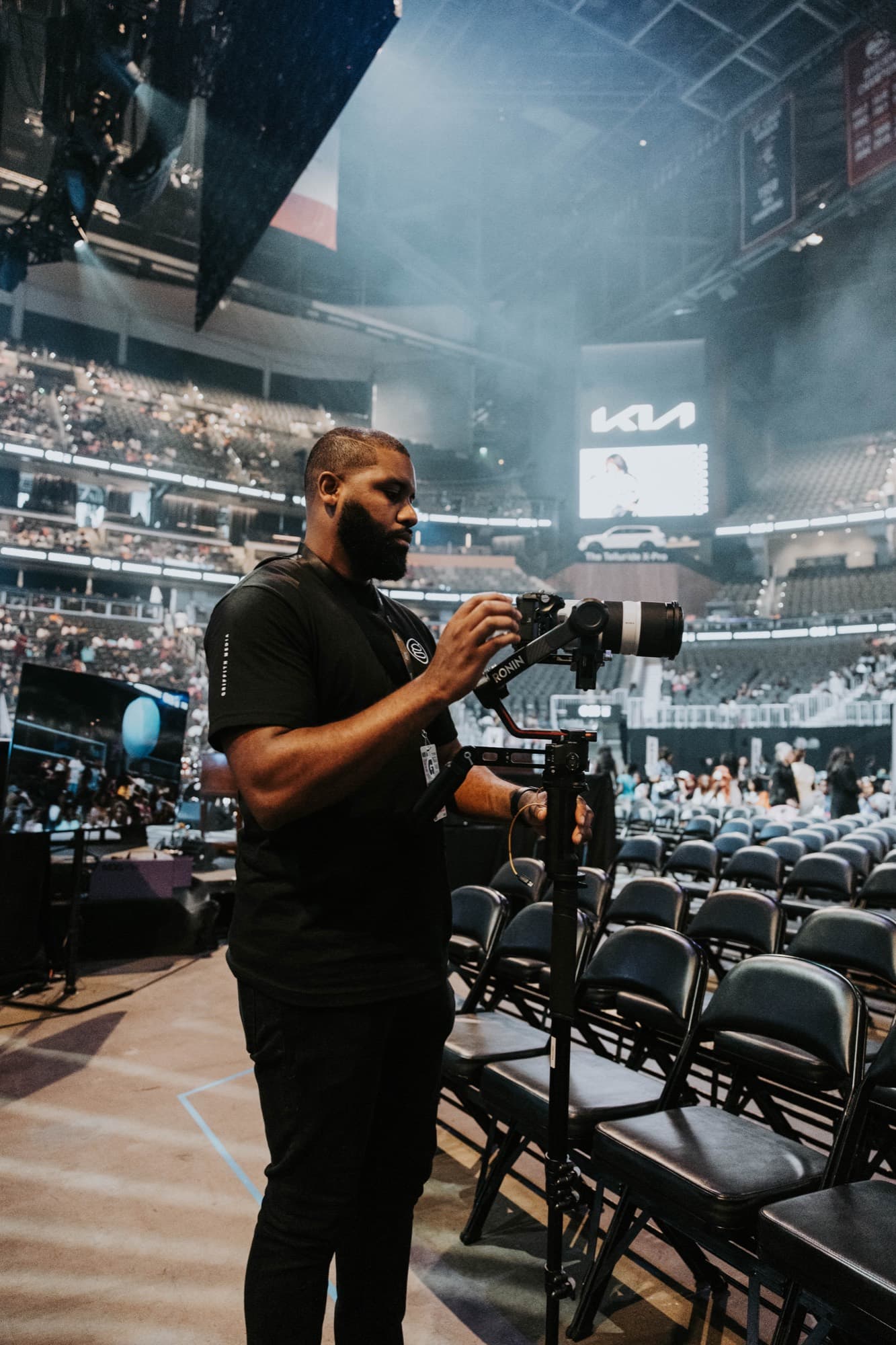 A Griffith Media operator shooting handheld gimbal into the State Farm Arena crowd