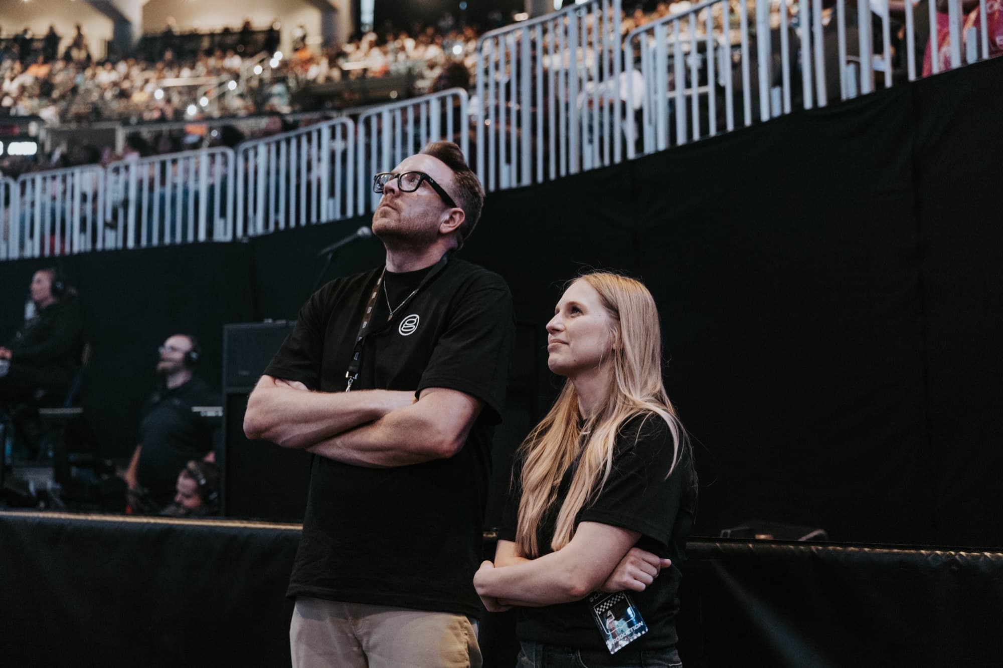 Paul and Grace Griffith standing at the arena barrier watching the recap play on the screens