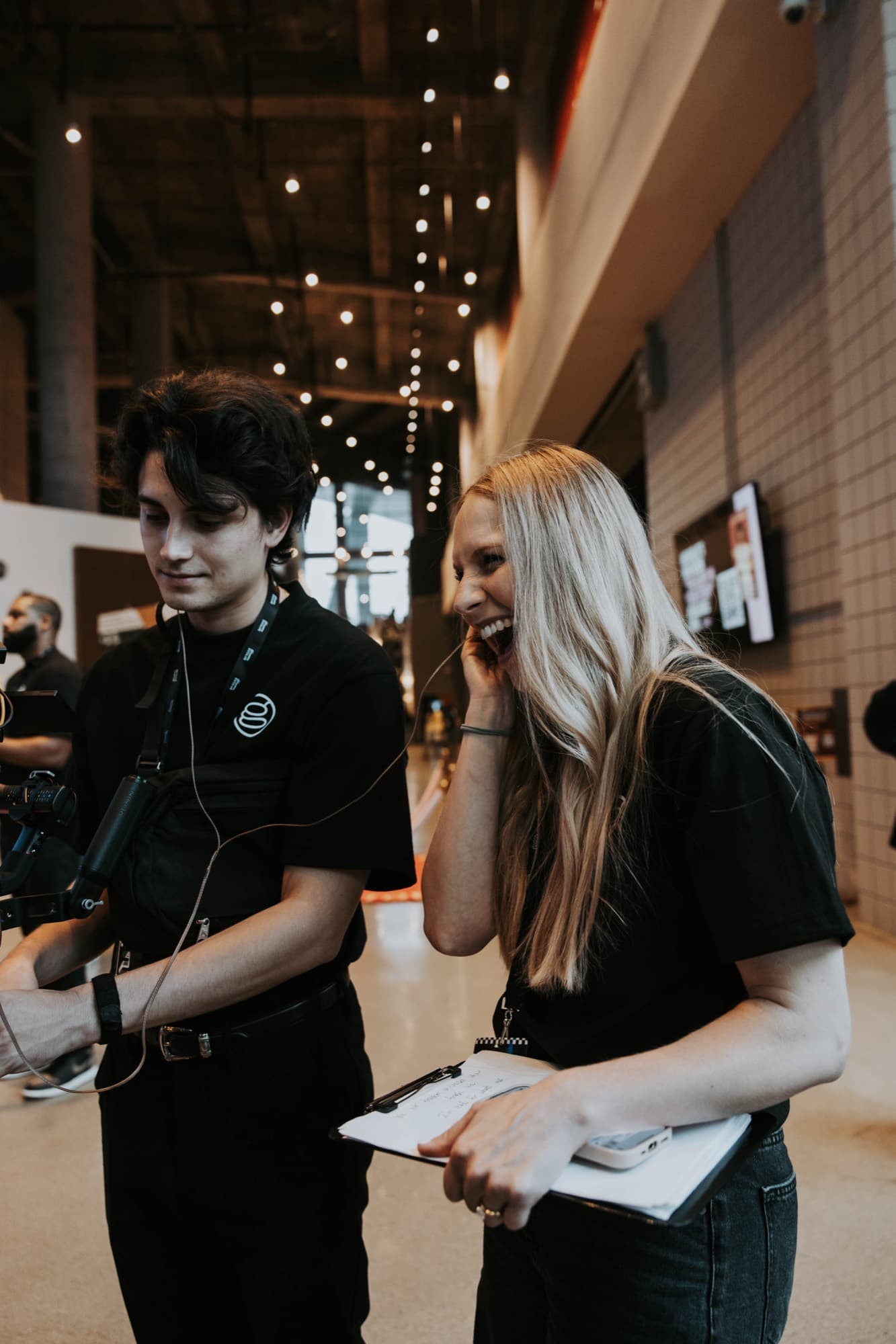 Two Griffith Media crew members laughing together between assignments at the venue